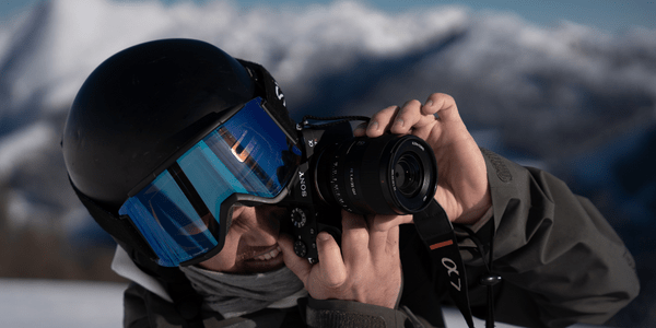 Content creator wearing Aleck helmet audio and ski goggles filming mountain vlog on action cam