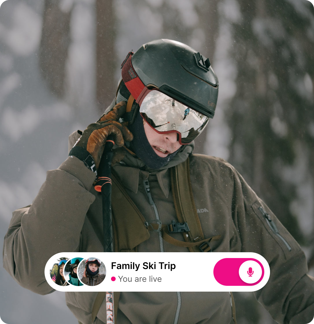 Skier using Aleck Connect App with live group communication feature during a snowy mountain trip