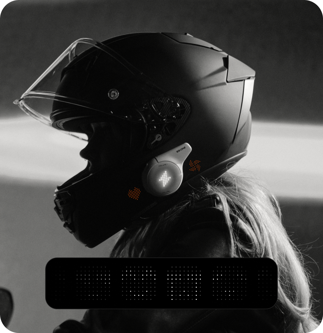 Person wearing a black motorcycle helmet with a blurred background