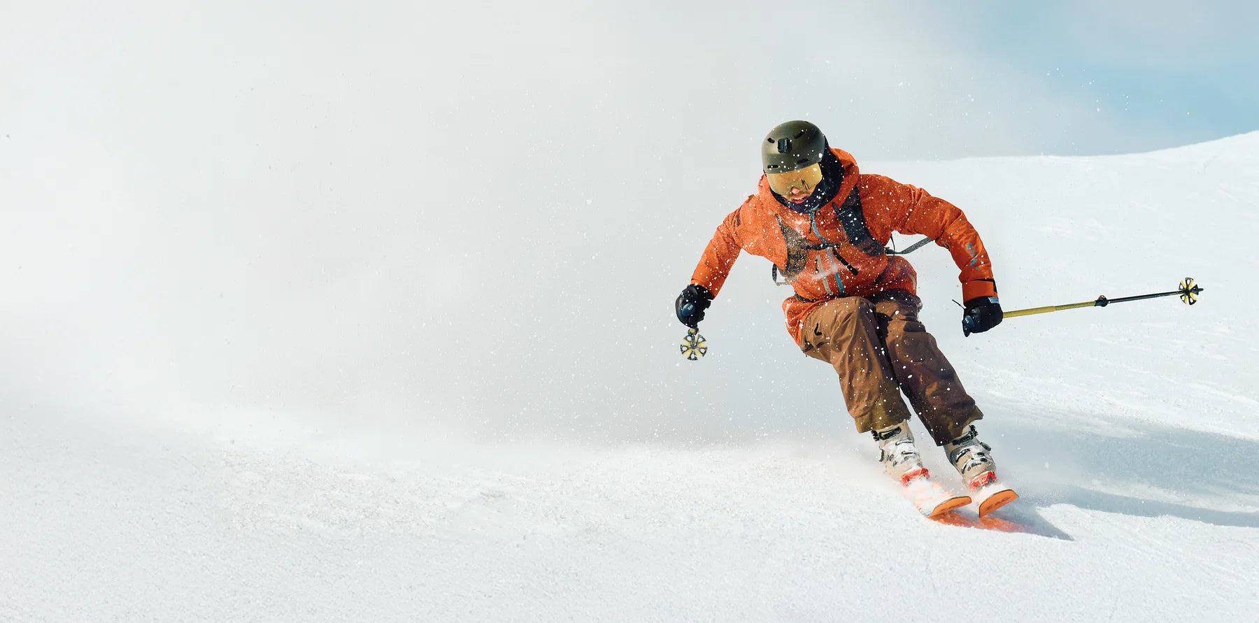 Skier carving powder in an Aleck-equipped helmet