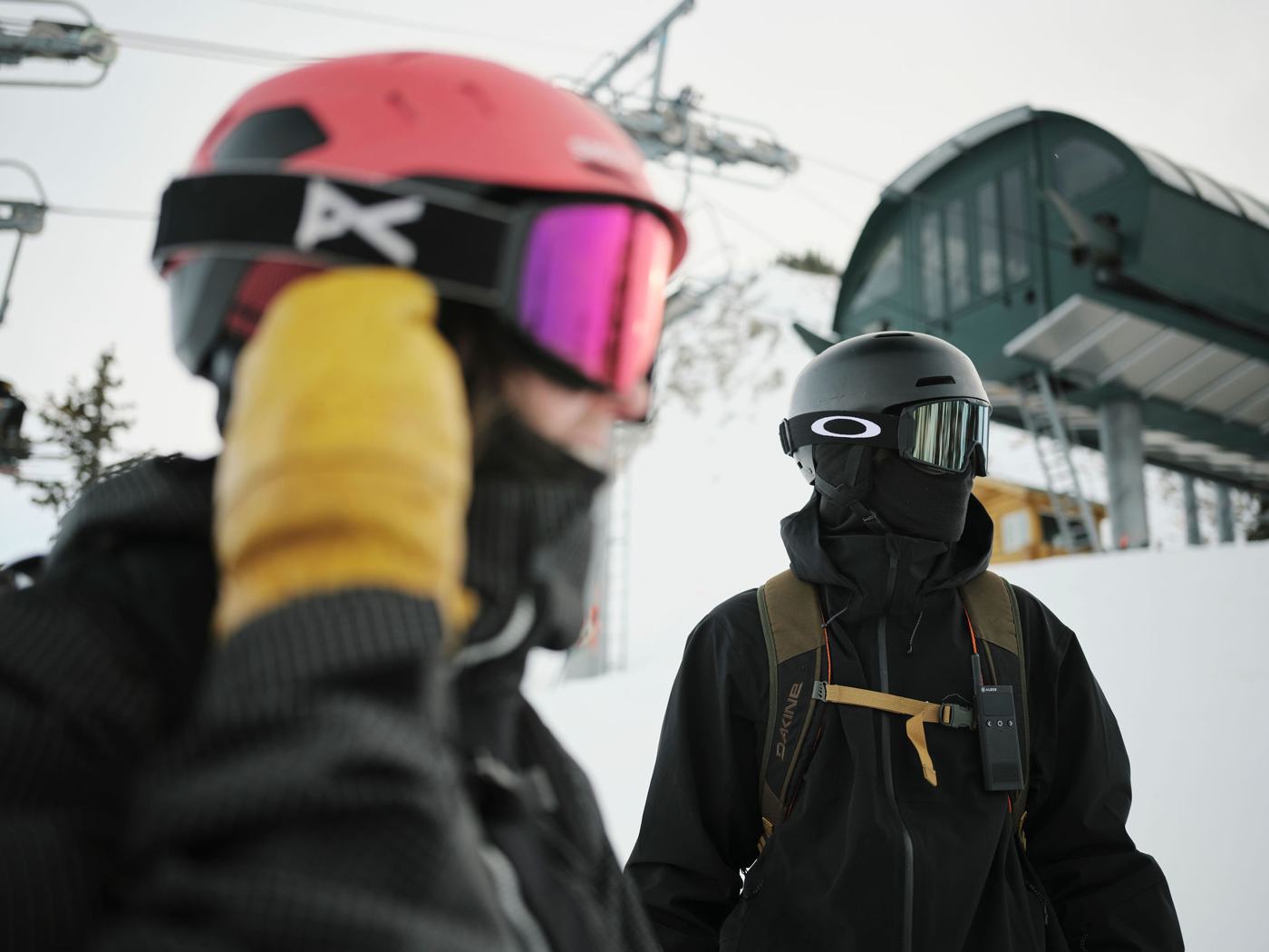 Two riders at the lift, Off Grid radio clipped to a chest strap